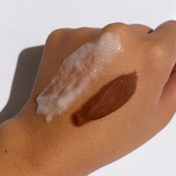 a hand with SLMD Glycolic Acid Body Scrub and self tanner