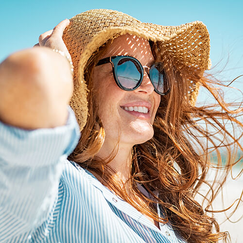Woman in a hat to protect against skin damaging UV rays