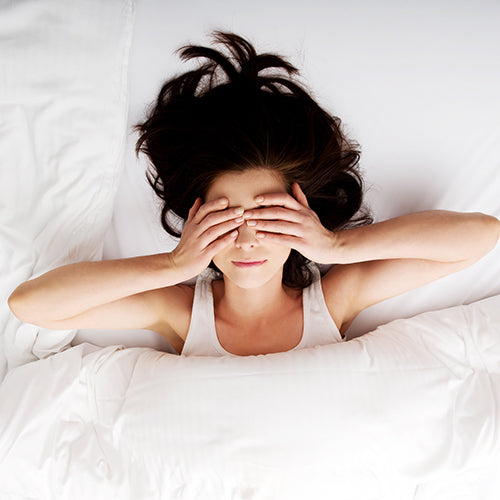 A woman waking up with a skin hangover after having alcohol the night before