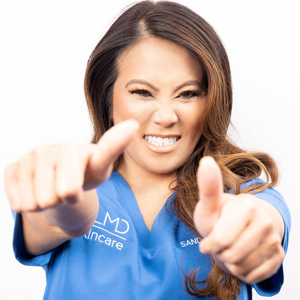 A photo of Sandra Lee MD aka Dr. Pimple Popper pretending to pop a pimple