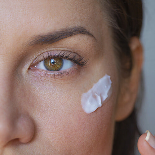 A woman with a swatch of nighttime retinol skincare