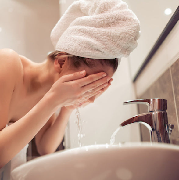 a woman cleansing, step one of a multi step skincare routine