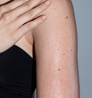 A woman using SLMD by Dr. Sandra Lee Glycolic Acid Body Lotion for keratosis pilaris and dry skin