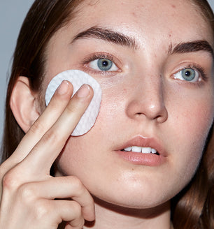 A woman using SLMD by Dr. Pimple Popper Resurfacing Acne Swipes for pimples and improved texture