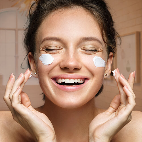 Smiling woman applying retinol cream