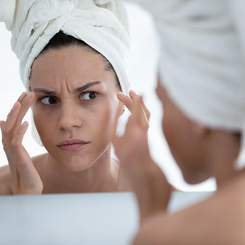 A woman looking at signs of aging on her face