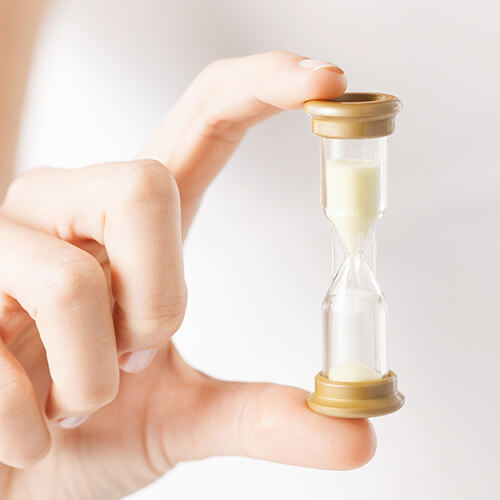 A woman holding an hourglass representing idea that skincare loses effectiveness over time