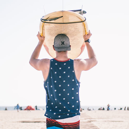 Photo of a man with the acne-prone part of his back and shoulders exposed at the beach