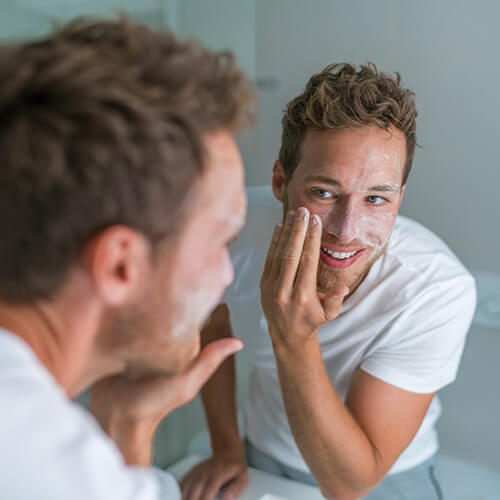 A man exfoliating his facial skin