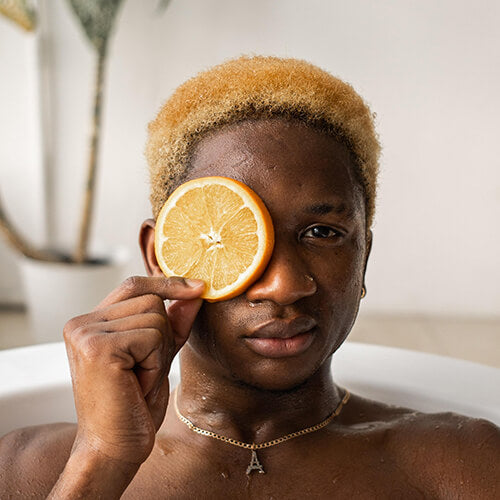 A man with an orange slice rich in antioxidant vitamin C 