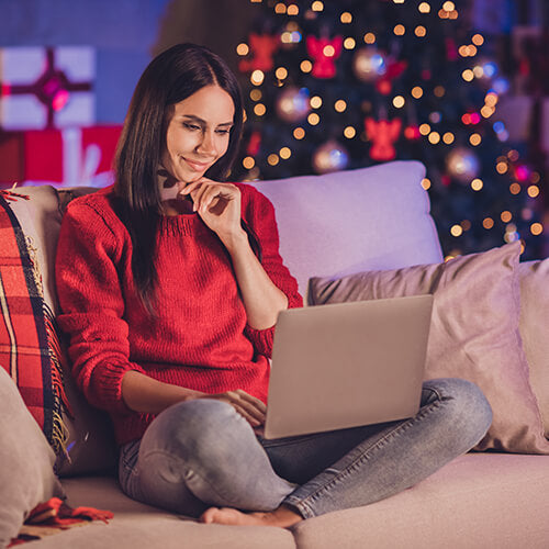 A woman online shopping for the holidays which can reduce stress