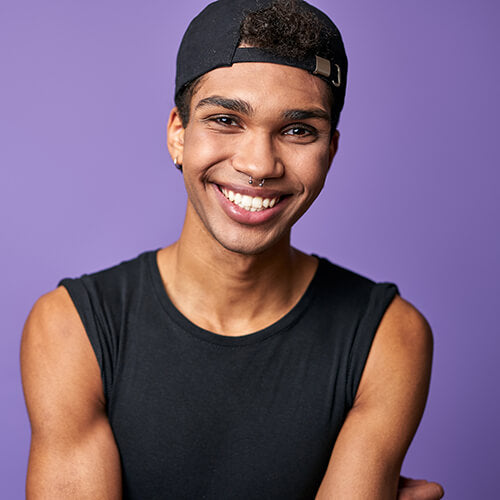 A smiling trans man with no acne