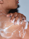 A man lathering SLMD BP Body Wash to treat inflammatory body acne