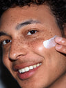 A man applying SLMD BP Lotion to treat inflammatory acne