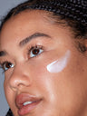 A woman applying SLMD Facial Moisturizer by Dr. Sandra Lee